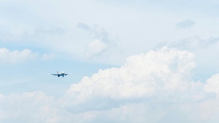 Passagierflugzeug fliegt vor einem bewölkten Himmel